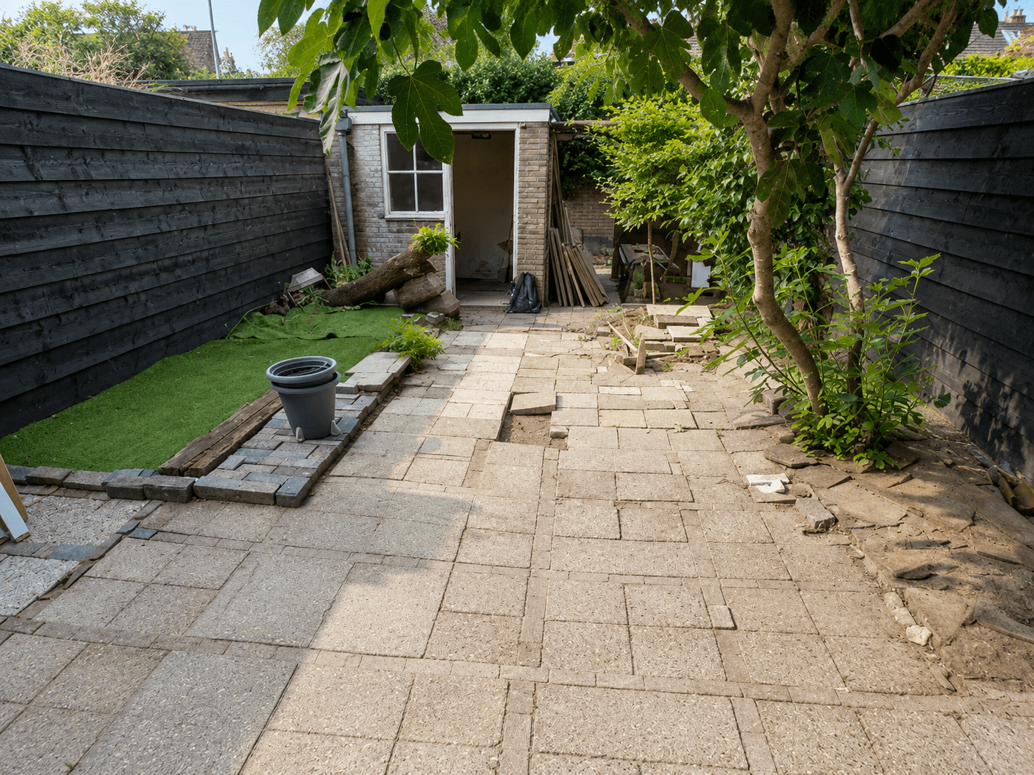 Worn, overgrown paving before the garden rebuild.